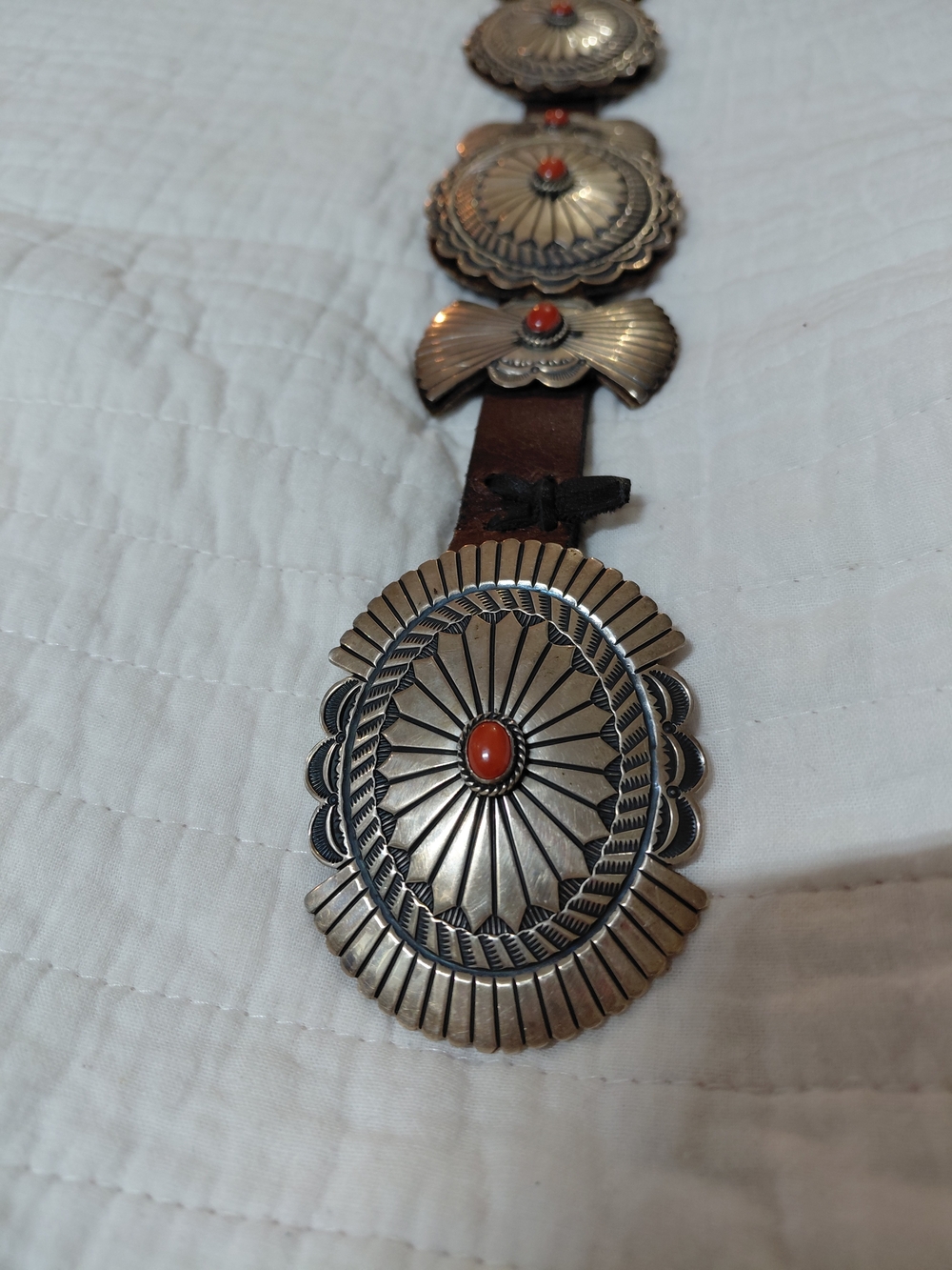 NATIVE AMERICAN STERLING SILVER & CORAL CONCHO ON LEATHER BELT.